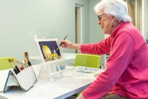 A woman painting fruit with watercolor paints